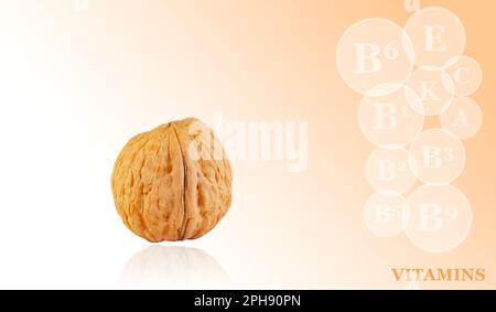 fresh kernels, broken and whole walnuts close-up isolated on color gradient background with markings of vitamins found in walnut Stock Photo