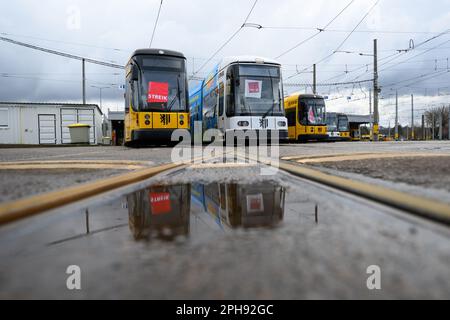 Dresden, Germany. 27th Mar, 2023. Streetcars of the Dresdner Verkehrsbetriebe (DVB) stand with strike posters and Verdi flags during the warning strike at the Trachenberge depot. With a large-scale nationwide warning strike, the unions EVG and Verdi have paralyzed large parts of public transport on Monday. Credit: Robert Michael/dpa/Alamy Live News Stock Photo