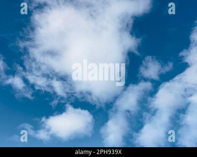Vast blue sky with scattered white cumulus clouds on a bright day Stock Photo