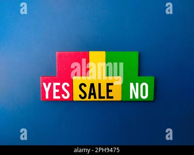 Top view colored wooden puzzle with the word YES SALE NO on blue background. Business concept. Stock Photo