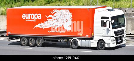 Side front view europa European road freight business trailer & name advertising graphic on a white MAN hgv lorry truck M25 motorway Essex England UK Stock Photo