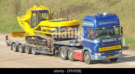 Netherlands NL country code on Scania 164L 480 lorry truck & low loader trailer JCB JS240 excavator wide load CONVOI EXCEPTIONNEL on UK motorway road Stock Photo