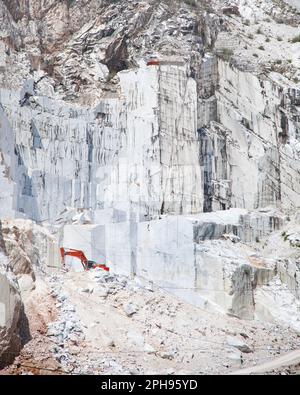 Carrara white marble quarry and an excavator. Tuscany region. Italy Stock Photo