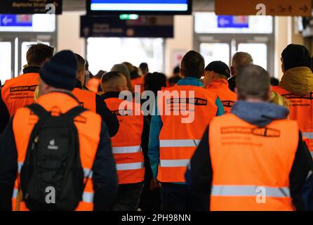 Dresden, Germany. 27th Mar, 2023. Participants of the warning strike walk through the main train station. With a large-scale nationwide warning strike, the unions EVG and Verdi paralyzed large parts of the public transport system on Monday. Credit: Robert Michael/dpa/Alamy Live News Stock Photo