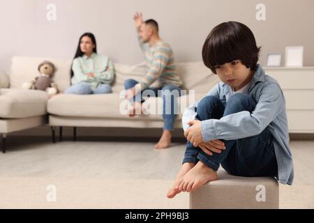 Couple arguing at home, focus on their upset child Stock Photo