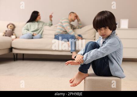 Couple arguing at home, focus on their upset child Stock Photo