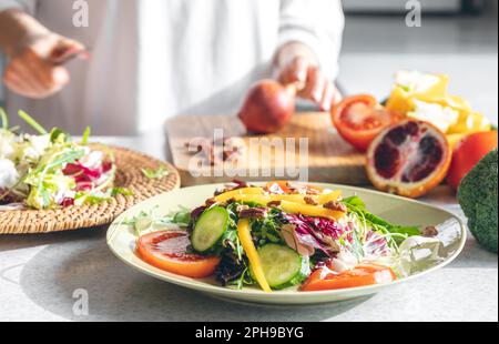 A woman makes a fresh vegetable salad, close-up. Stock Photo