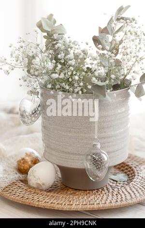 Light Easter composition with Easter eggs and gypsophila flowers. Stock Photo