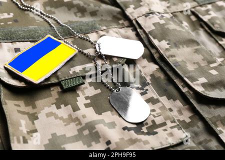 Ukrainian army flag patch and military ID tags on camouflage uniform Stock Photo