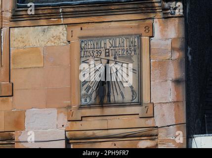 Stating Greenwich Solar Time and dated 1877, this sundial can be found on the High Street, Peebles in the Scottish Borders. Stock Photo