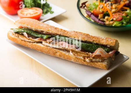 Serranito Sandwich. Typical Spanish sandwich with pork loin, bacon and fried green pepper. Stock Photo