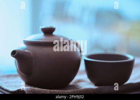 Teapot and tea cup made of yixing clay stands on a tea tray. Chinese traditional gongfu cha teaware Stock Photo