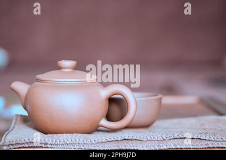 Chinese brown clay teapot and cup. Traditional chinese tea ceremony utensils. Tea brewing equipment Stock Photo