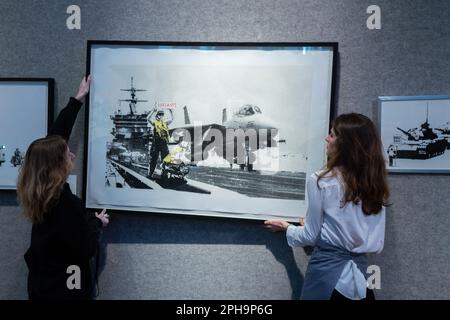 London UK 27 March 2023. Art handlers hanging  Applause (LA Edition), 2006 by Banksy (born 1974). Estimate £15,000 - £20,000. The sale takes place 29 March at Bonhams New Bond Street. Credit: amer ghazzal/Alamy Live News Stock Photo
