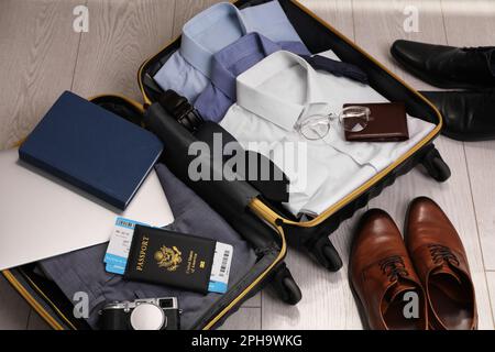 https://l450v.alamy.com/450v/2ph9wkg/open-suitcase-with-mens-clothes-accessories-and-shoes-on-floor-2ph9wkg.jpg