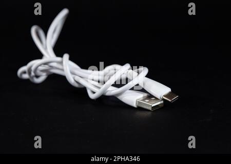 Picture of a cable with two types of port, USB A and USB C, used for charging smartphones. USB A and C are major standards for USB plugs and ports. Stock Photo