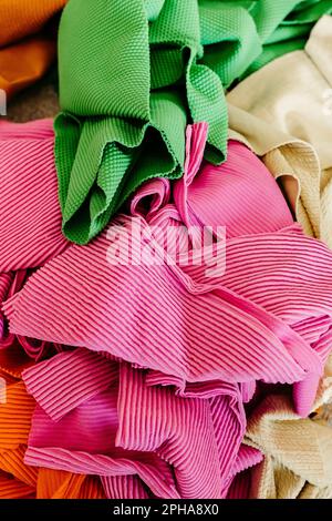 A vibrant vertical shot showcasing an assortment of fabrics, including cotton, linen, and wool, stacked atop one another Stock Photo