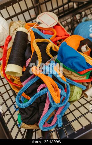 A selective focus closeup of a variety of cables and cords of various colors stored in a woven basket Stock Photo