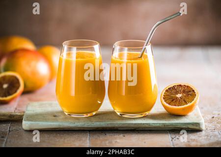 Two mango lassi or kesar milk in glasses. Indian healthy ayurvedic cold drink with mango. Freshness lassi made of yogurt, water, spices, fruits and ic Stock Photo