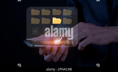 Businessman touching document folder on a mobile screen. an extension of digitization and process automation to efficiently manage files, knowledge, a Stock Photo