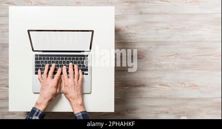 Hands of man over laptop with blank screen. Top view with empty copy space. Stock Photo