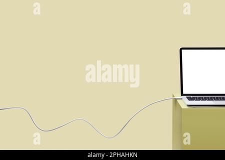 Laptop on colored pedestal with cable. Yellow background. Connection concept. Stock Photo