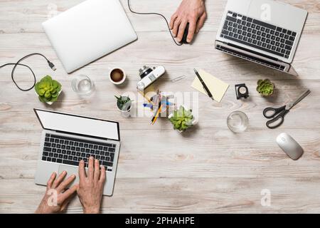 High angle view of office table with people working at laptop. Stock Photo