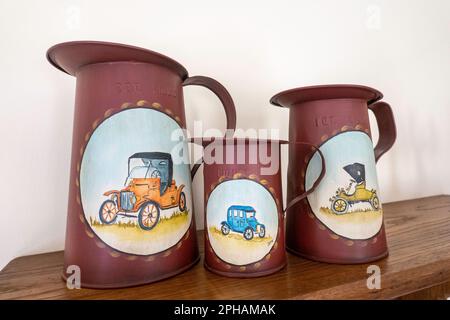 Close-up of a set of three antique measuring cans with tole painted designs, Bucks County, Pennsylvania, USA Stock Photo