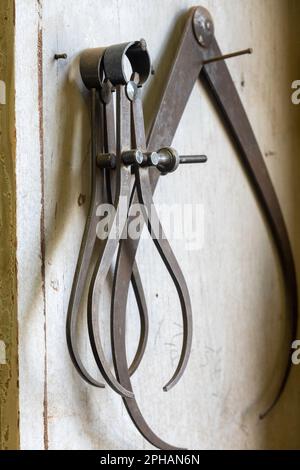 Close-up of various sized antique calipers, hanging in a residential workshop, 2023, Bucks County, Pennsylvania, United States Stock Photo