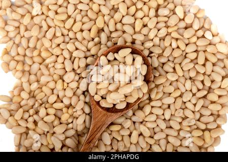 Top view of peeled pine nuts and wooden spoon with pine nuts. Copy space. Stock Photo