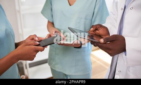Cropped wide shot of doctors hands using digital tablets in scrubs at hospital Stock Photo