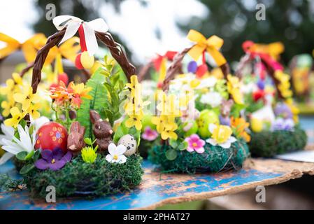 beautiful Easter decoration in traditional spring colors with Easter eggs, bunnies decorated with spring flowers - golden rain and primrose sold at an Stock Photo