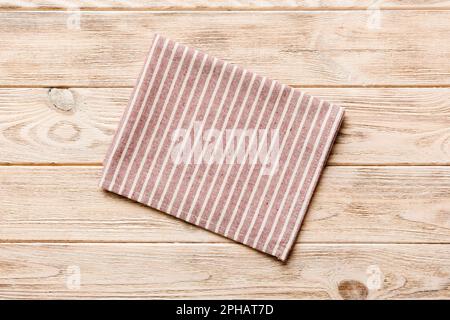 top view with red empty kitchen napkin isolated on table background. Folded cloth for mockup with copy space, Flat lay. Minimal style. Stock Photo