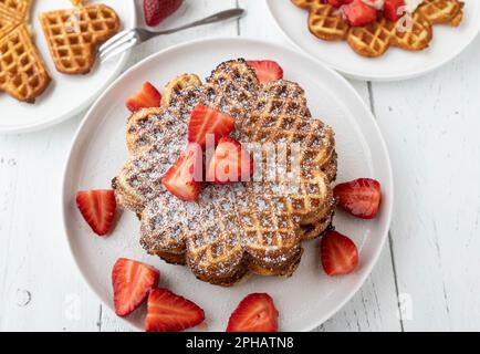 Waffle stack with fresh strawberries on white background from above Stock Photo