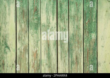 Old weathered faded paint wooden board garden wall closeup as green grunge background Stock Photo