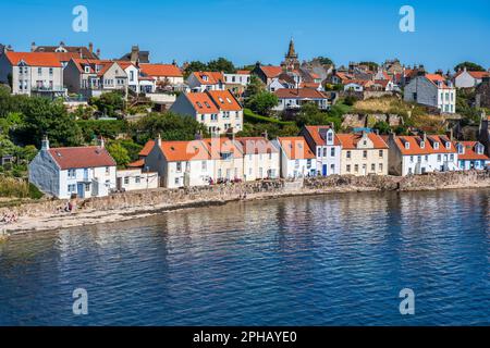 View looking across bay to colourful red-roofed houses on seafront of Pittenweem in East Neuk of Fife, Scotland, UK Stock Photo