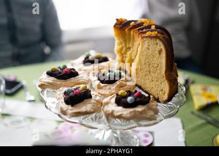 Traditional Easter dishes with white borscht, sausage, eggs, salad and cakes on festive table in Poland. Home interior with easter decor. Spring Stock Photo