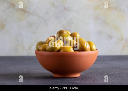 Bowl full of green olives on black background Stock Photo