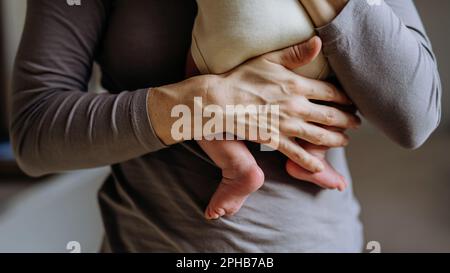 Low section of mother holding her newbron baby. Stock Photo