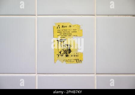 Stuttgart, Germany. 27th Mar, 2023. A sticker is stuck on a wall of the visitors' restroom of the former multi-purpose building at Stuttgart-Stammheim Prison. The courtroom at the prison in Stuttgart-Stammheim, which became known nationwide almost 50 years ago due to proceedings against terrorists of the Red Army Faction (RAF) group, will be demolished in the next few months. Credit: Marijan Murat/dpa/Alamy Live News Stock Photo