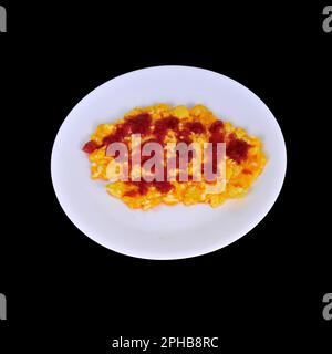 Scrambled Eggs, cheese,and Mexican Salsa on a white plate over black isolated Stock Photo