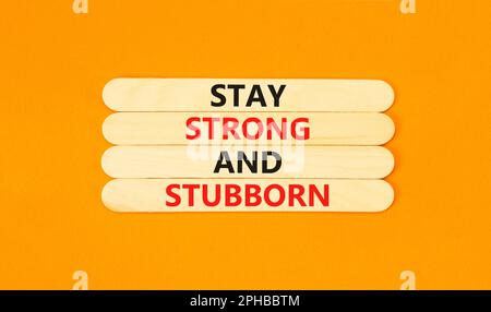 Stay strong and stubborn symbol. Concept words Stay strong and stubborn on wooden stick. Beautiful orange table orange background. Motivational busine Stock Photo