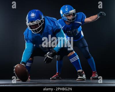 Two American football players are ready to start the game on a black background.  Stock Photo