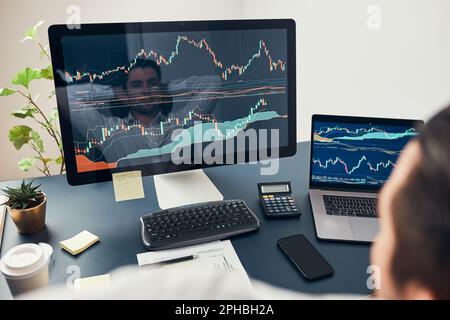 Businessman trading stocks online. Stock investor analysing numbers at graphs and charts. Investor planning and analysing stock market profiit. Man wo Stock Photo