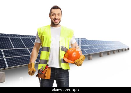 Construction worker holding a helmet and wearing a tool belt at a solar farm isolated on white background Stock Photo
