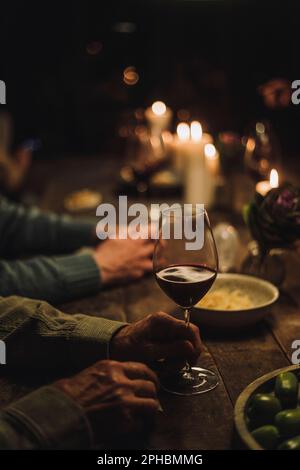 Hand of senior man holding wineglass at dining table during party Stock Photo