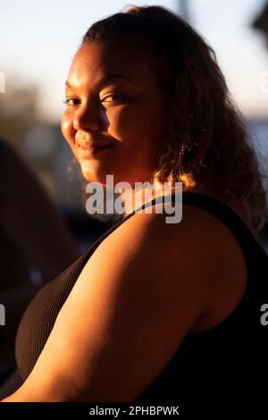 Side view portrait of smiling voluptuous woman Stock Photo