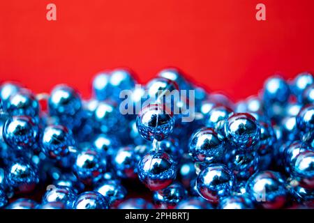 Blue Beads on a Red Background. Copy Space for Text. Macro Close-up. Background of Many Colored Beads Necklace. Stock Photo