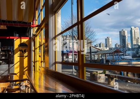 City skyline views from inside Granville Island market of the waterfront and high-rise condominium buildings along False Creek in Vancouver, BC Stock Photo