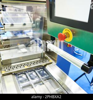 Conveyor at food factory for packing plastic containers Stock Photo